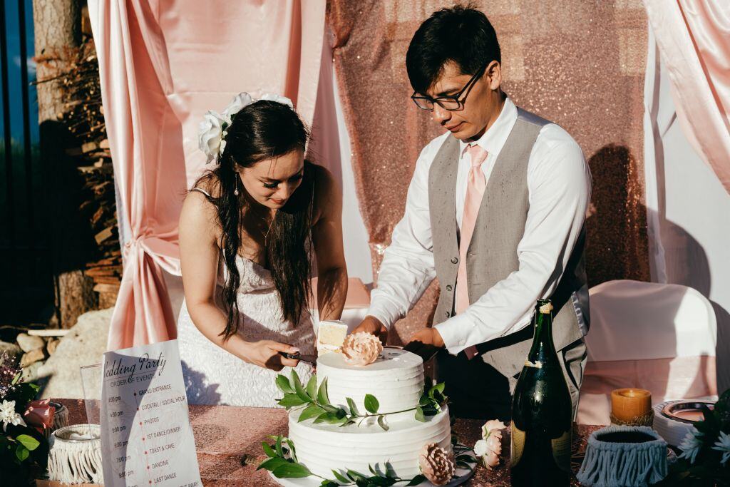 bride and groom cutting wedding cake